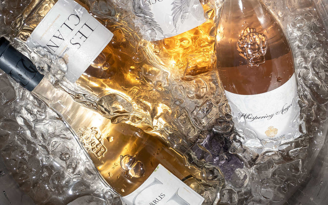 Bottles of rosé and white wine chilling on ice for a summer villa